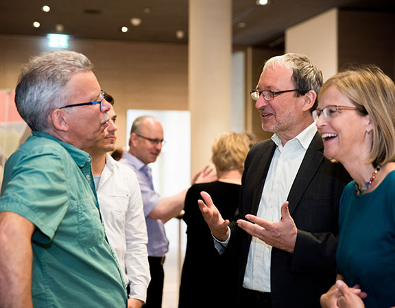 Dr. Schoeps gestikuliert mit den Händen bei einem Kundengespräch